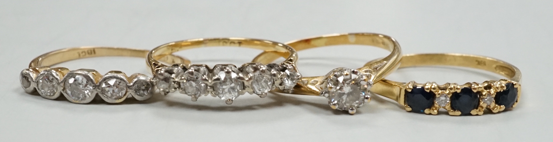 Three assorted modern 18ct and diamond set rings including solitaire size M and an 18k, sapphire and diamond chip ring, gross weight 8.1 grams.